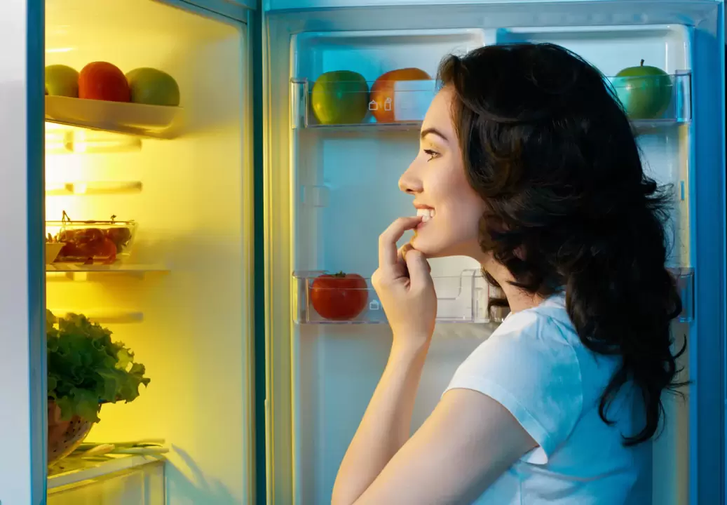the girl looks in the fridge during a quick weight loss