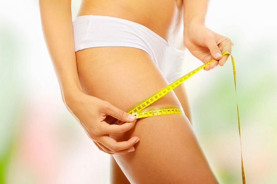 The girl measures the volume of the thigh